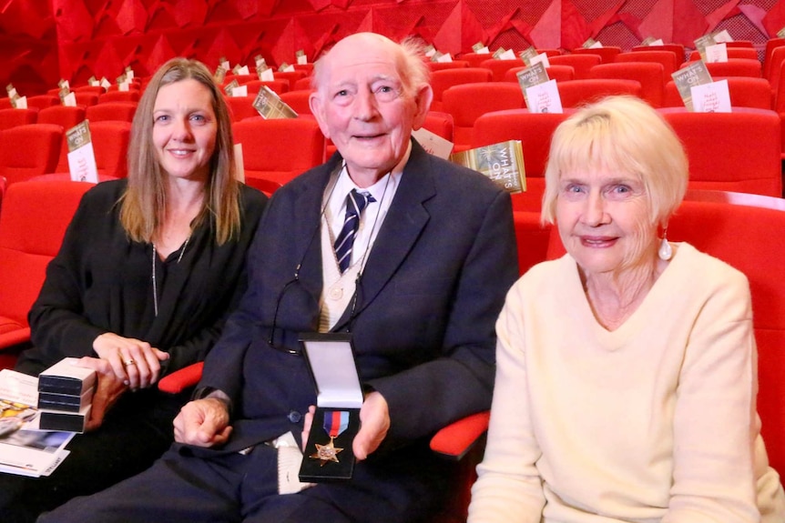 Bill Stewart sitting between two family members.