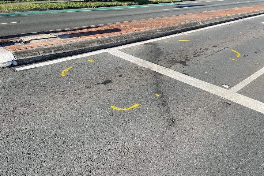 Police paint on a road, strewn with oil, where the pedestrians were killed.