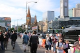 Pedestrians walk along Princes Bridge, near Flinders St Station.