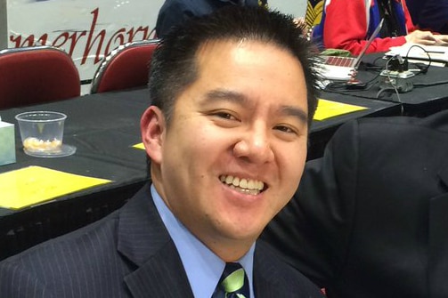 A cropped headshot of Robert Lee smiling as he sits at a commentary table