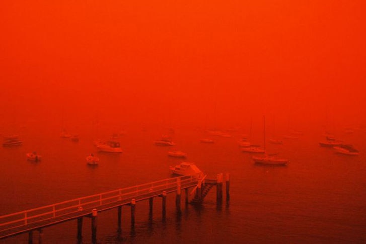 The Double Bay marina is enveloped in red dusty haze as a storm moves over Sydney on September 23, 2