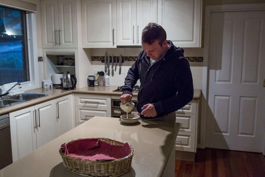 Chris May pours milk into a bowl of cereal.