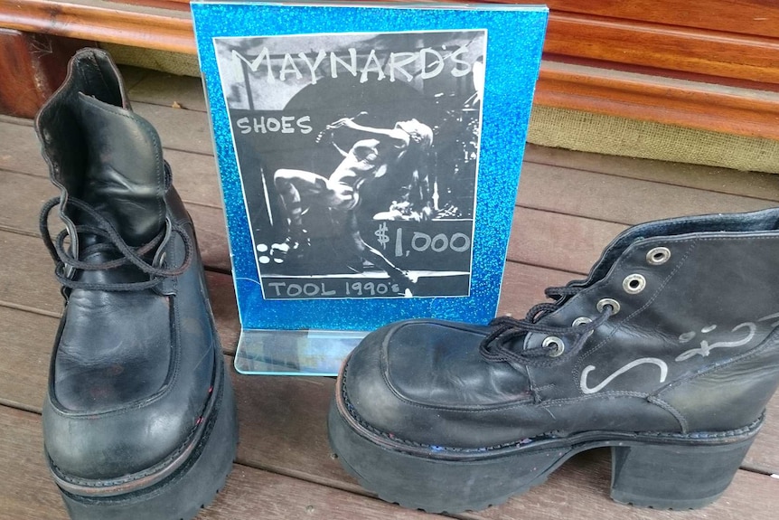 A pair of well-worn boots belonging to Maynard James Keenan and a display sign advertising their price of $1,000