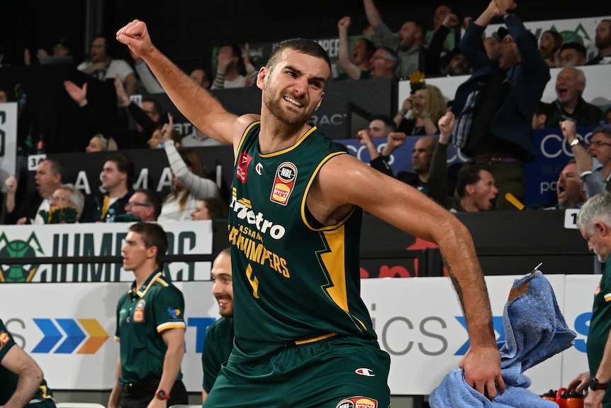 Jack McVeigh punches the air while running on court.