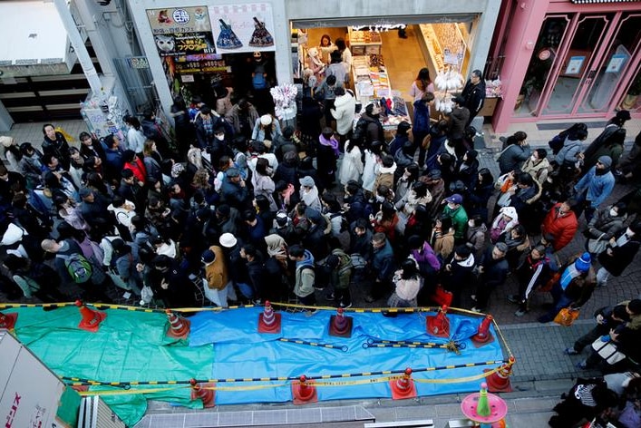 Pedestrians walk past a site where a vehicle ploughed into crowds in a Harajuku street