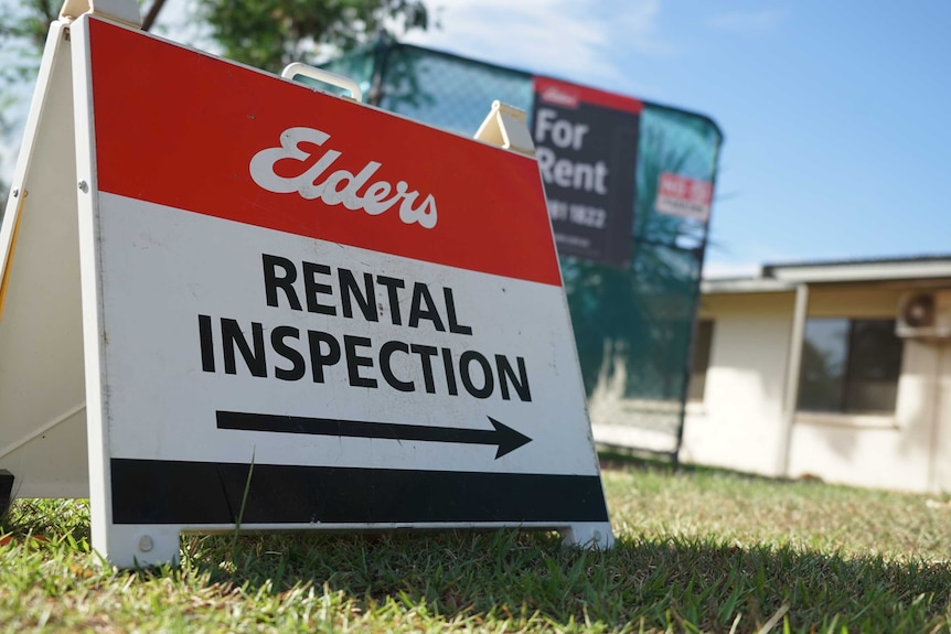 An Elders real estate sign, low to the ground with a fence in the background.