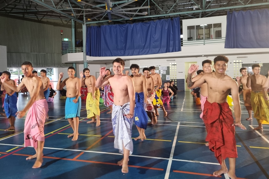 Rows of young Samoan teens wear ie lava lava in school hall as the practice for their performance. 