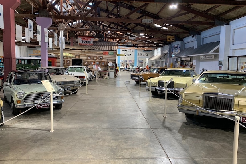 1970s cars lined up inside a large warehouse.