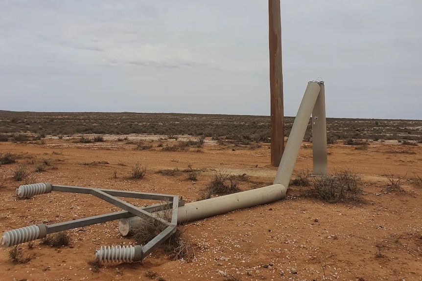 A new power pole next to another fallen power pole in Far West New South Wales.