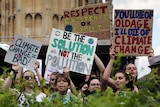 Climate change demonstrators hold placards during a march outside the Houses of Parliament in London.