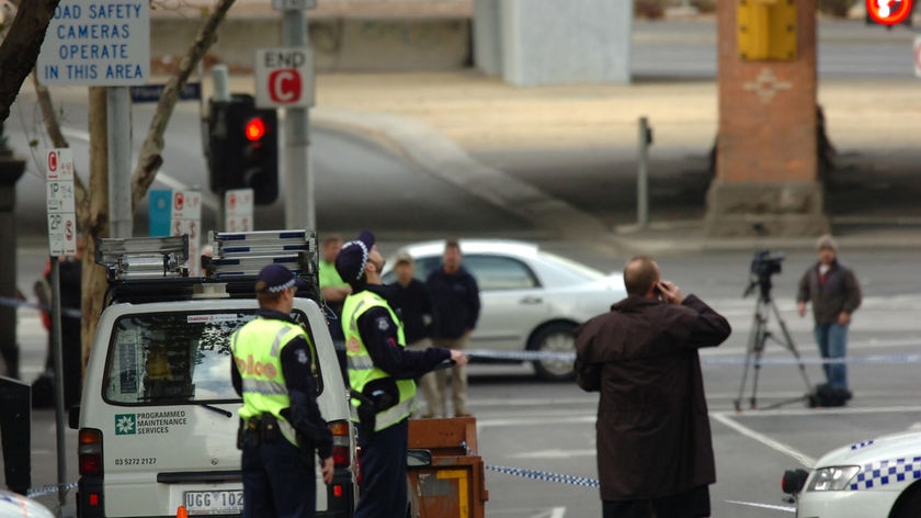 Shooting: A police officer walks past the body of the victim