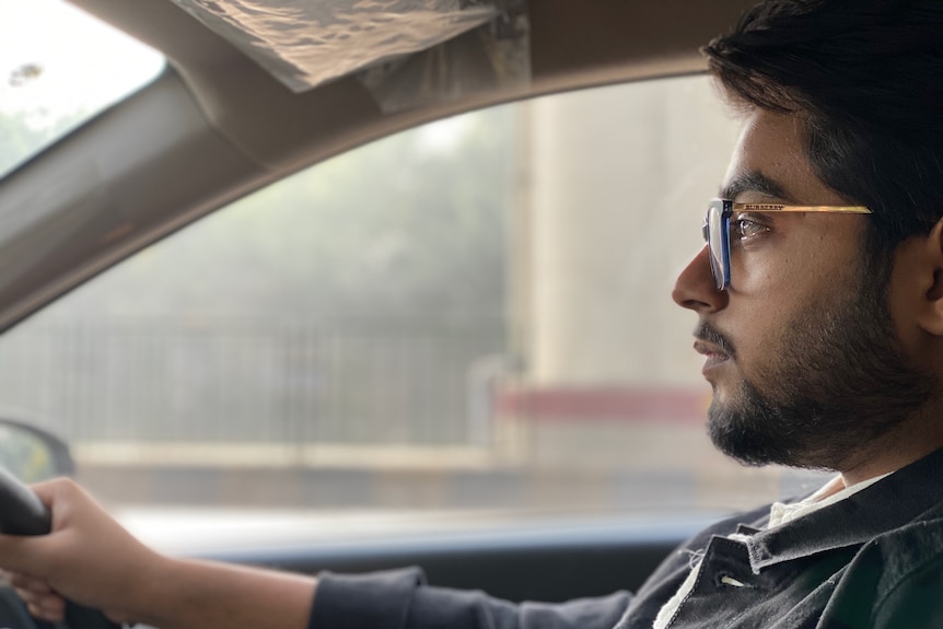 Man looking at the road while driving a car, experiencing some nervousness and fear.