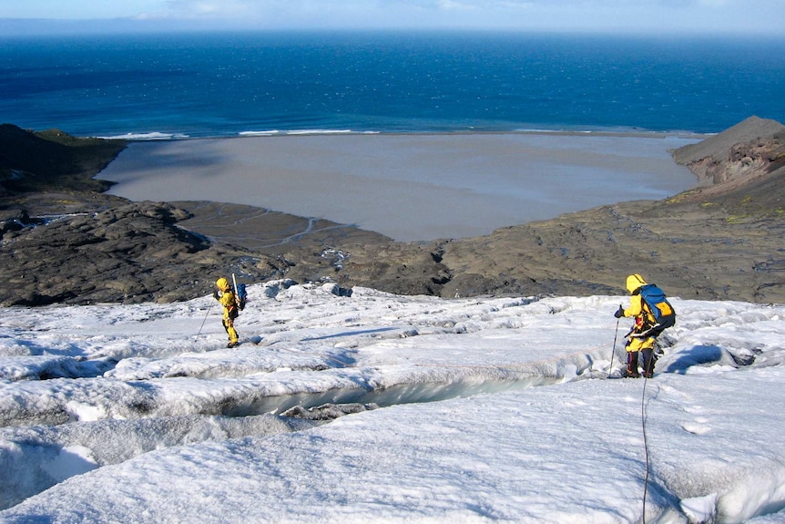 Explorers walk down a snowy slope