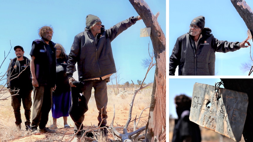 He stands next to the tree and points at a piece of tin attached to it