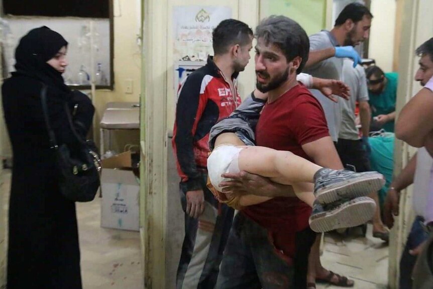 A child is carried after Russian airstrikes