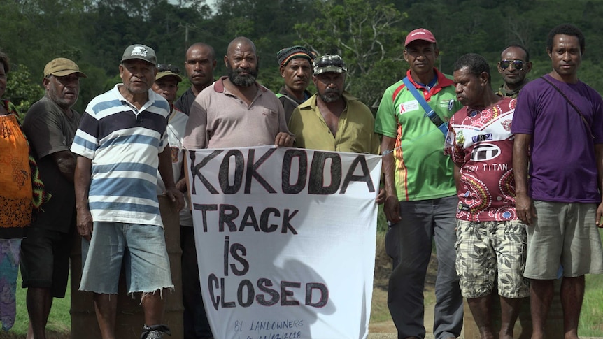 A group of landowners stand by their blockade of the Kokoda Track