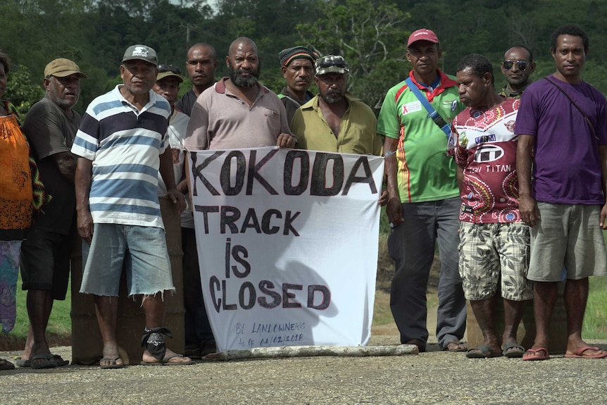 A group of landowners stand by their blockade of the Kokoda track