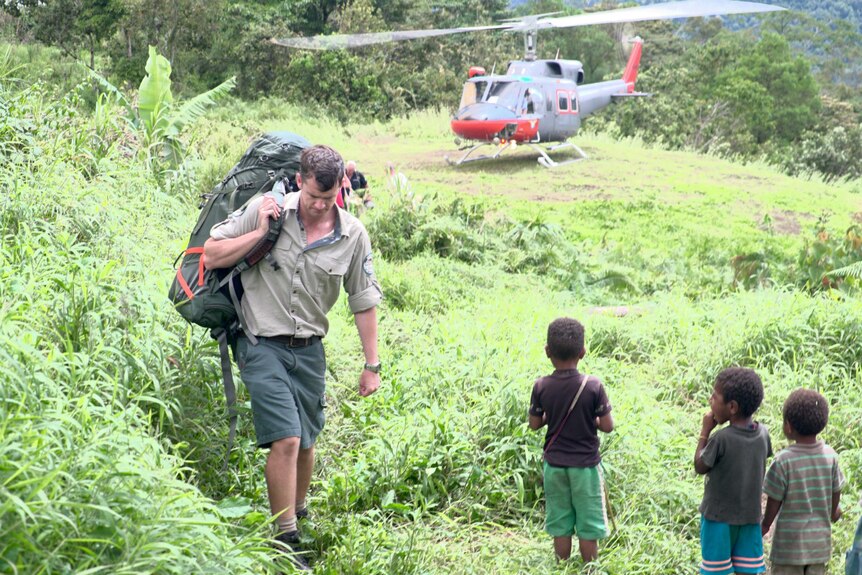 Ranger Pat Kirby brings his gear off the helicopter at Launumu village.