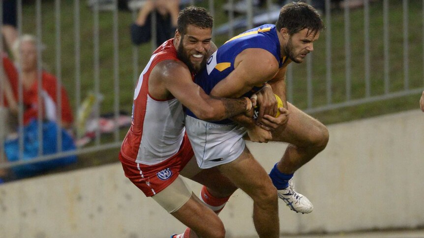 Mitch Brown playing against Lance Franklin during a 2014 preseason fixture.