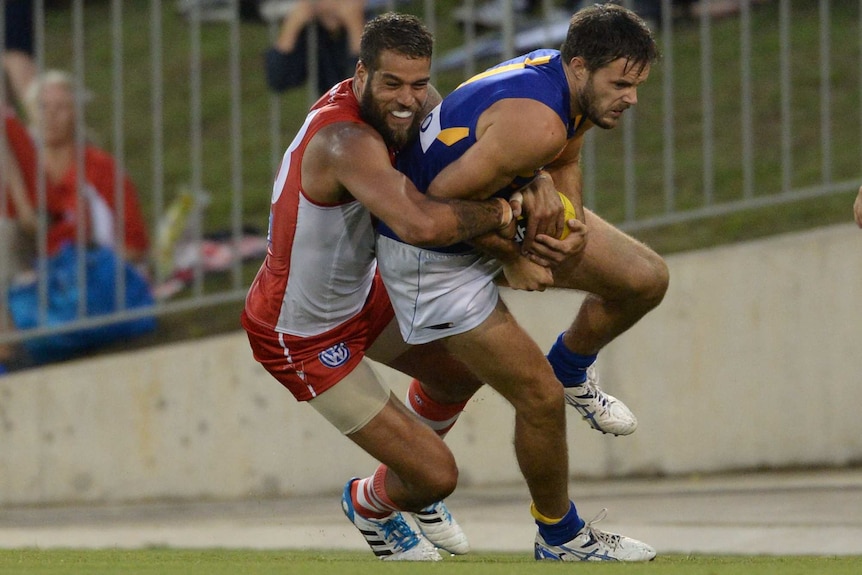 Mitch Brown playing against Lance Franklin during a 2014 preseason fixture.