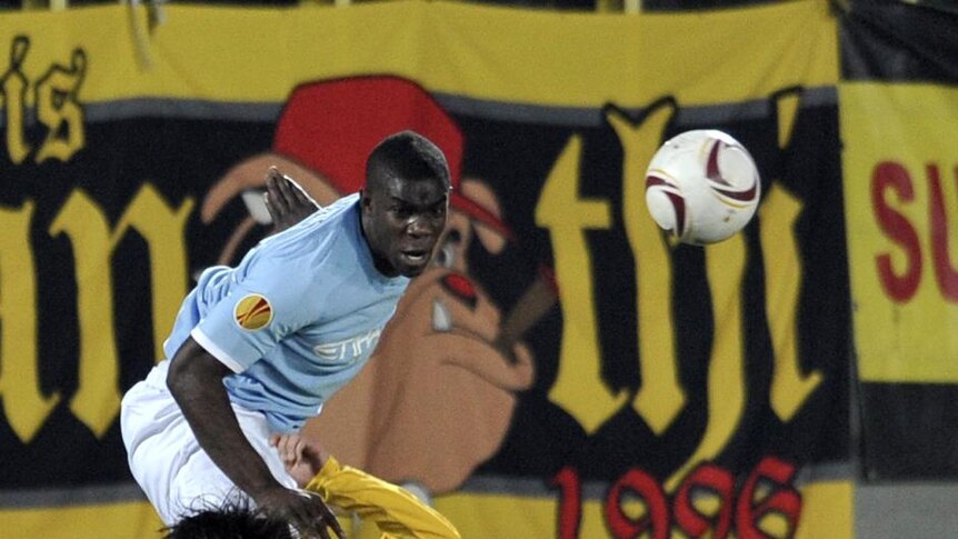 Manchester city defender Micah Richards leaps over his Aris Salonika opponents.