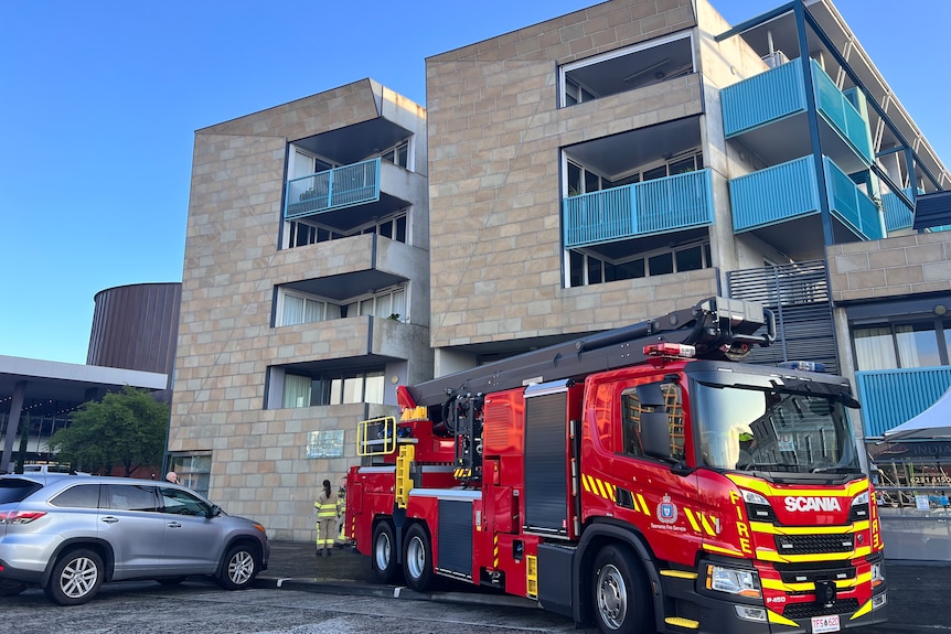 A red fire truck outside an apartment block