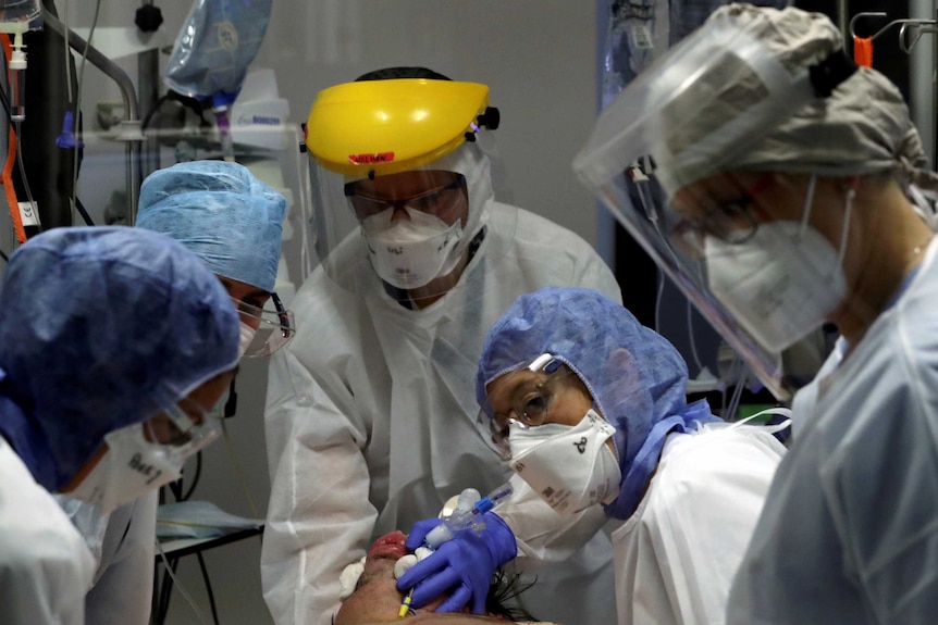 Medical staff surround a patient on oxygen