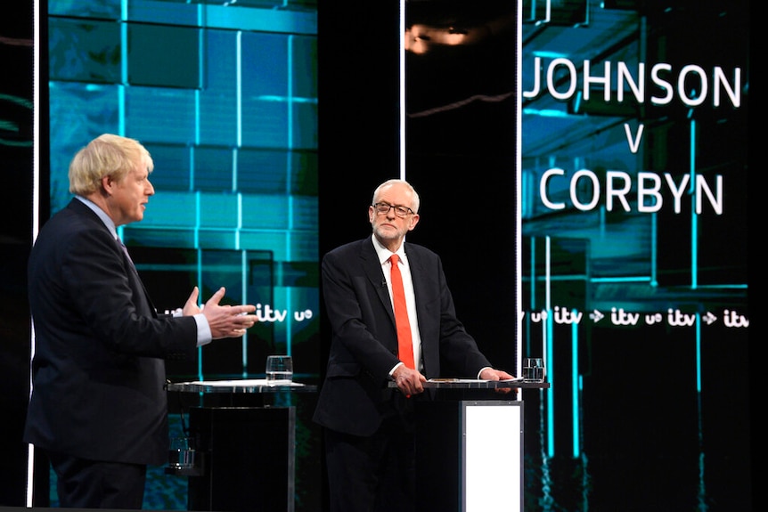 From a distance, you view Boris Johnson and Jeremy Corbyn on a live ITV set surrounded by screens.