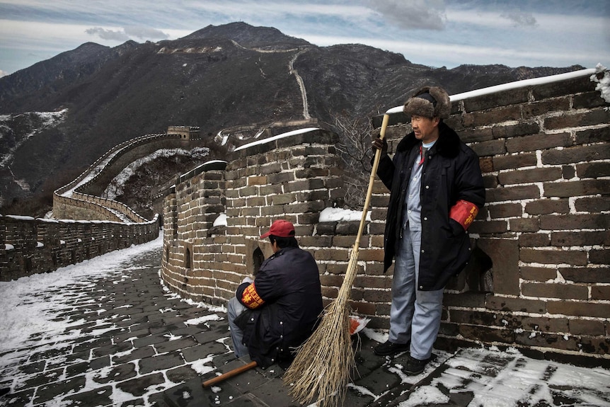 Chinese workers take a break from shovelling and sweeping after a snowfall on the Great Wall in Mutianyu.
