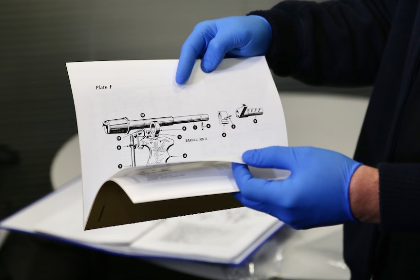 A book with a black and white diagram of components of a gun.