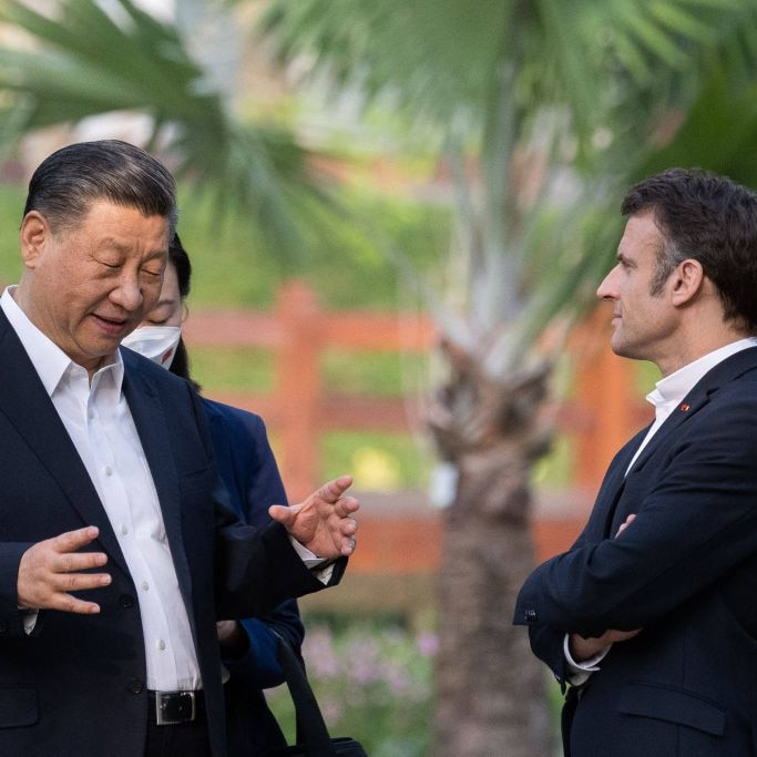 Presdients Xi Jinping ( China ) and Emanuel Macron ( france) stand and talk in a garden 