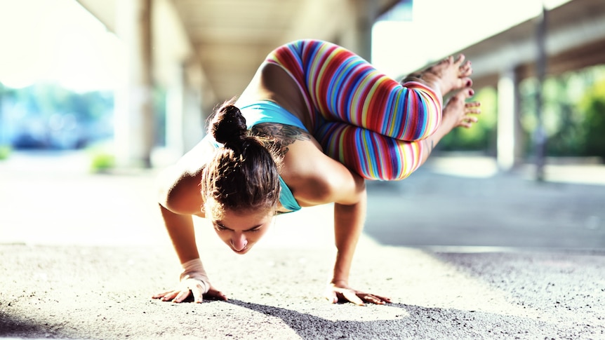 A woman does a yoga exercise demonstrating her strong core muscles.