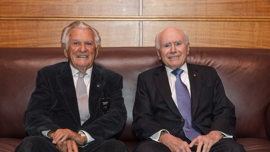 Former Prime Ministers Bob Hawke and John Howard sit on a couch