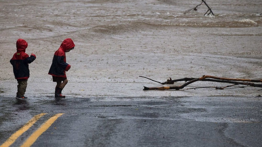 Children stand on flooded road in Texas
