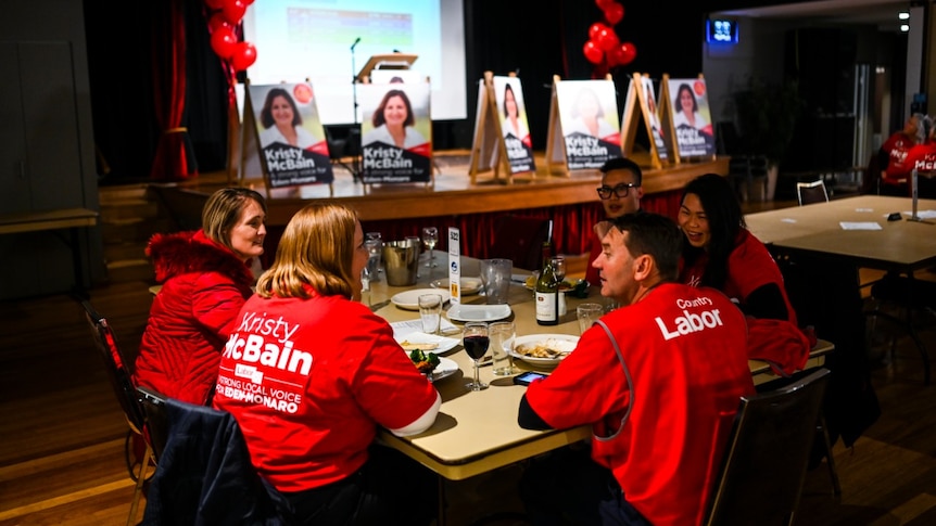 A group of people sitting around a table, eating.