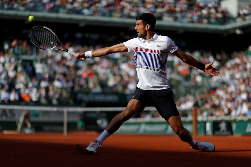 Novak Djokovic stretches for a backhand return against Albert Ramos-Vinolas.