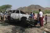 People gather at the site of a drone strike in the southern Yemeni province of Lahj on August 11, 2013.