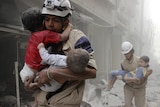 White Helmet volunteers in Syria carry children
