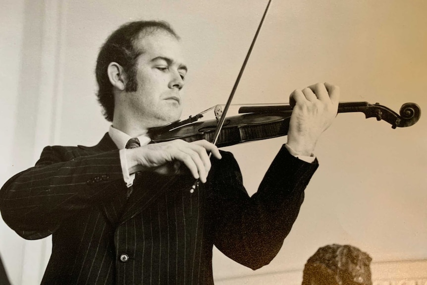 A black and white photo of a man playing guitar