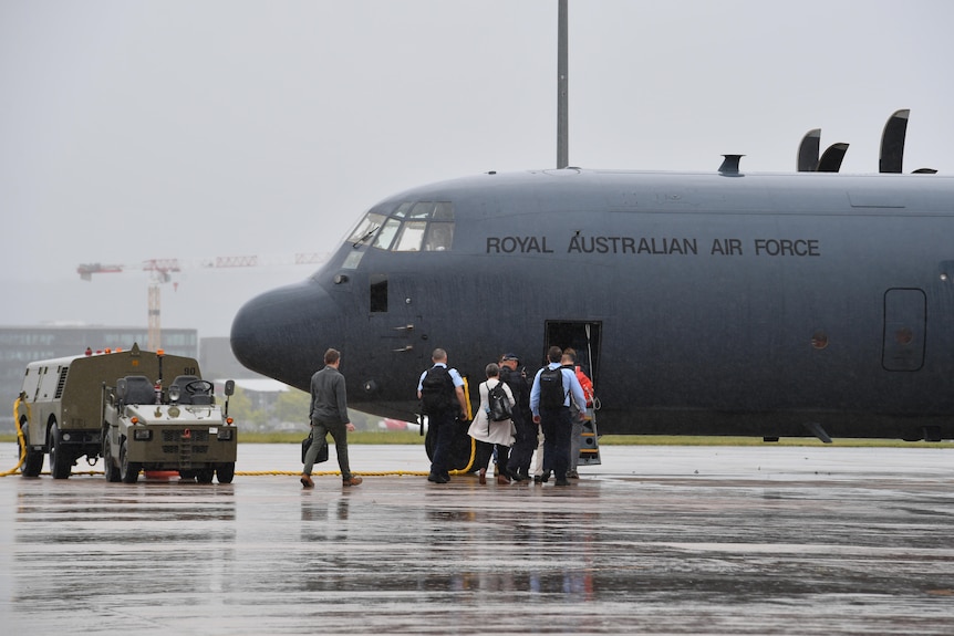 Australian Defence Force members walk towards RAAF plane