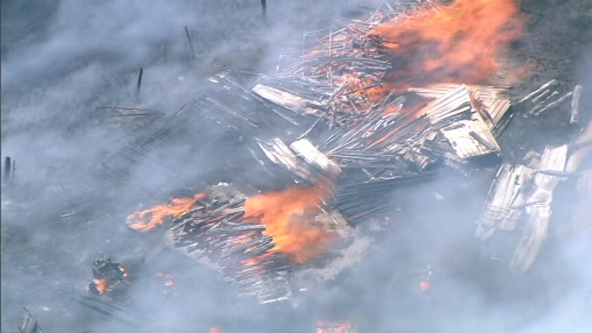 A structure or stockpile of material burns on a rural property