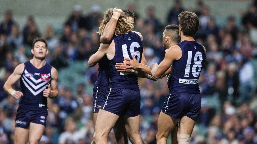 Fremantle players celebrate a goal against Essendon at Subiaco Oval on June 4, 2016.