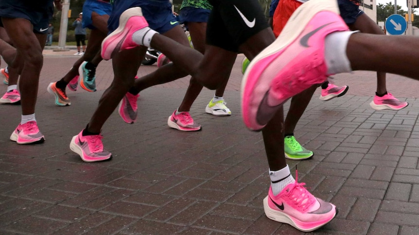 A large group of runners wearing pink and green shoes.