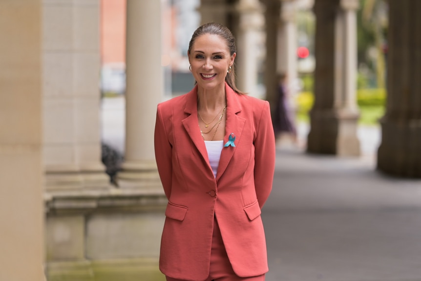 A women in a pink suit smiling 