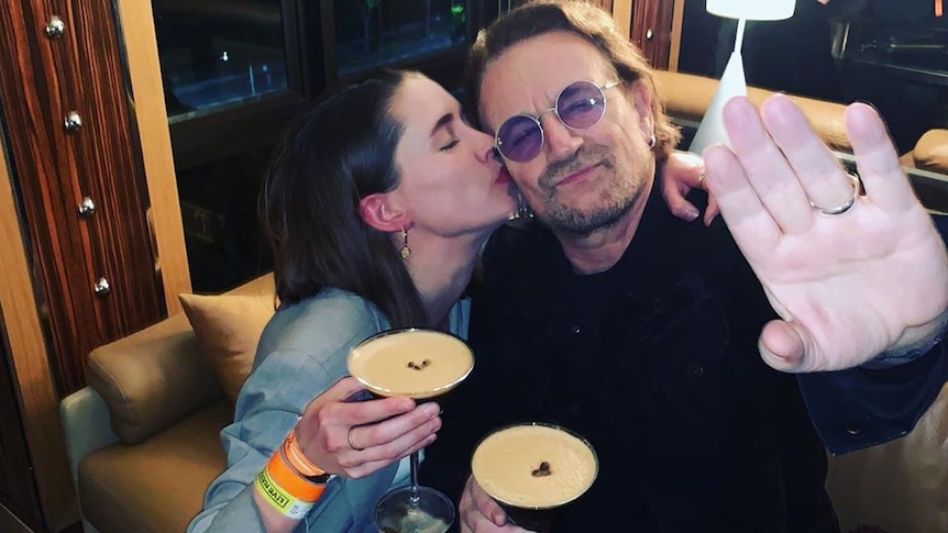 Confidence Man singer Janet Planet kissing U2 frontman Bono on the cheek while drinking espresso martinis