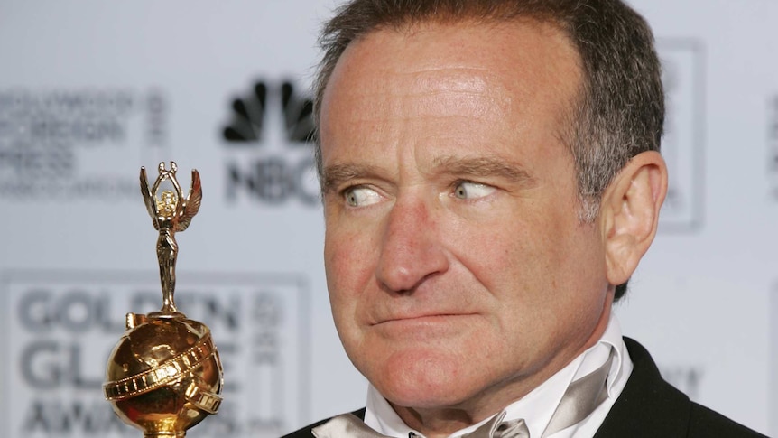 Robin Williams poses with an award at the Golden Globes