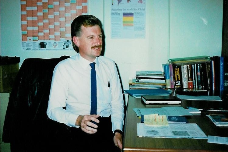 Man in white shirt and tie sitting in office 