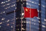 The Chinese national flag is flown in front of an office building.