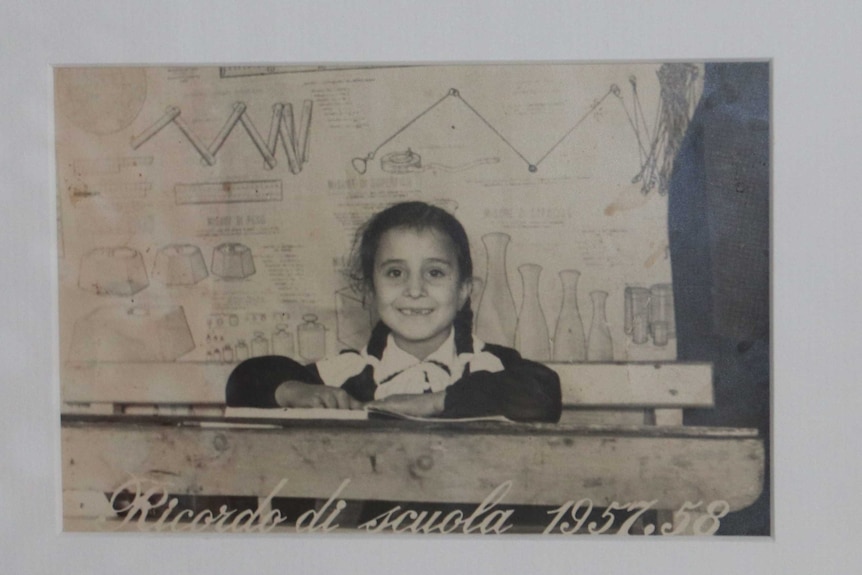 An old photo of a young girl with plaits against a background filled with science