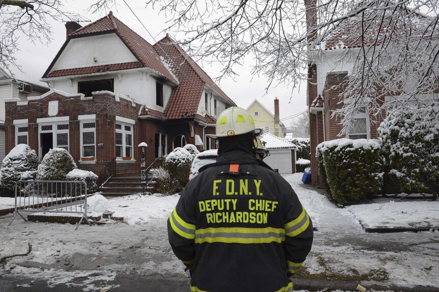 Firefighters near the site of a deadly Brooklyn house fire
